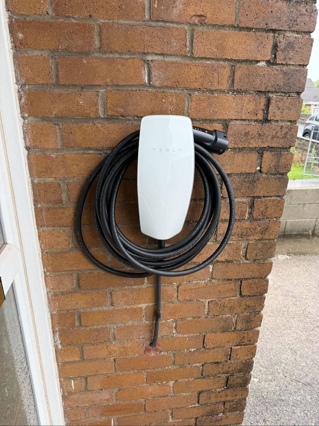 New Tesla EV charger installed on house wall